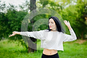 Portrait of a cheerful girl in nature. with black hair and painted hoods in a white T-shirt. natural emotions. Beautiful smiling