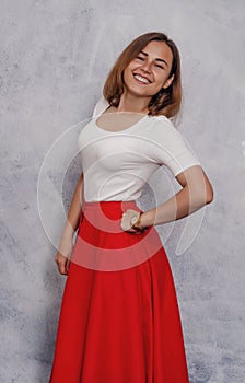 Portrait of a cheerful girl, smiling ironically. Red skirt