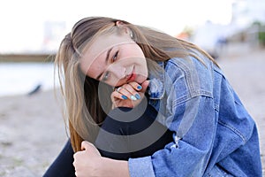 Portrait of cheerful girl who poses on camera and cute laughs si