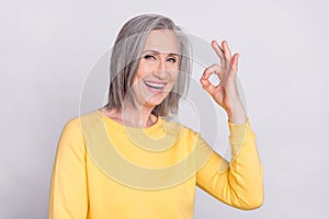 Portrait of cheerful good mood beautiful mature woman showing thumb-up excellent isolated on grey color background