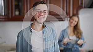 Portrait of cheerful happy man looking back at woman holding dessert turning to camera crossing hands smiling. Confident