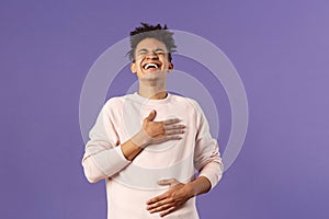 Portrait of cheerful, happy young hipster guy laughing out loud from hilarious joke, watching awesome stand-up performer