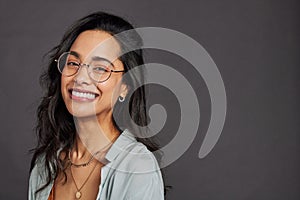 Portrait of cheerful hispanic woman with eyeglasses smiling