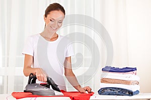 Portrait of cheerful housewife ironing clothes.