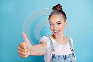 Portrait of cheerful lady showing thumb up screaming wearing white t-shirt denim jeans isolated over blue background