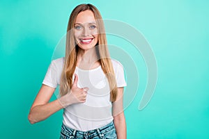 Portrait of cheerful lady showing thumb up smiling at camera wearing denim jeans isolated over teal turquoise background