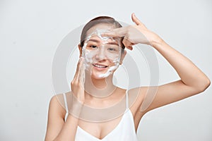 Portrait of cheerful laughing woman applying foam for washing on her face