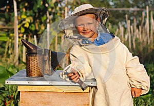 Portrait of a cheerful little boy beekeeper
