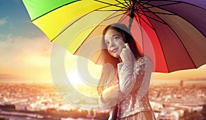 Portrait of a cheerful little girl relaxing under an umbrella