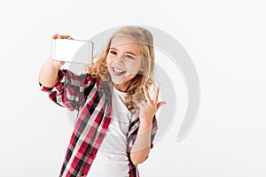 Portrait of a cheerful little girl taking a selfie