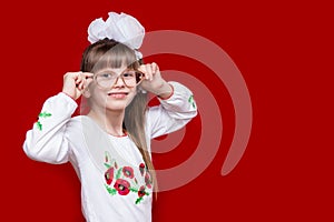 Portrait of cheerful little girl in very big glasses and white bow. Concept of eyesight or teaching