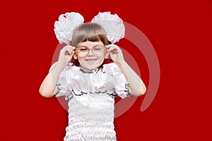 Portrait of cheerful little girl in very big glasses and white bow. Concept of eyesight or teaching