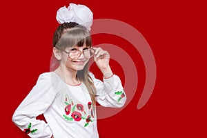 Portrait of cheerful little girl in very big glasses and white bow