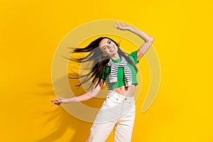 Portrait of cheerful lovely girl toothy smile flying hair dancing have good mood isolated on yellow color background