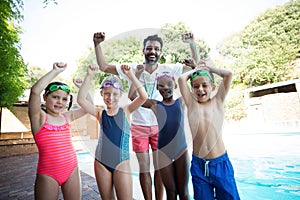 Portrait of cheerful male instructor with little swimmers