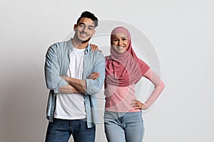 Portrait Of Cheerful Millennial Muslim Couple Posing Together On Grey Background