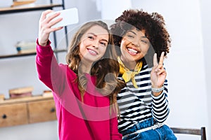 portrait of cheerful multiracial young women taking