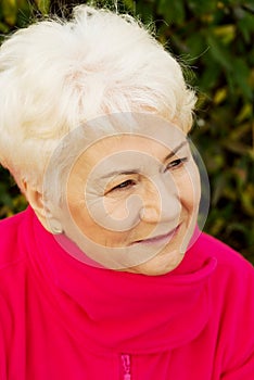 Portrait of a cheerful old lady over green background.