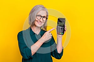 Portrait of cheerful person indicate finger hand hold demonstrate wireless paypass isolated on yellow color background