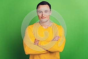 Portrait of cheerful positive cool guy folded hands on green background