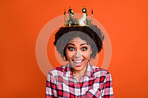 Portrait of cheerful pretty girl toothy smile wear golden crown isolated on orange color background
