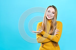 Portrait cheerful pretty young lady standing isolated over blue background. Looking camera showing copyspace