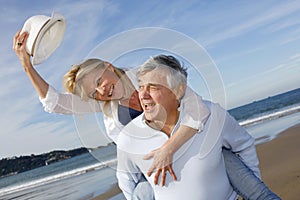 Portrait of cheerful senior couple on the beach having fun