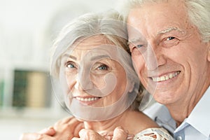 Portrait of cheerful senior couple embracing at home