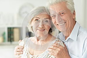 Portrait of cheerful senior couple embracing at home