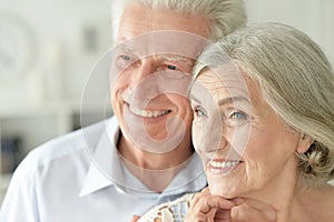 Portrait of cheerful senior couple embracing at home