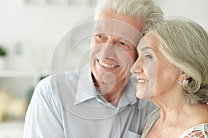 Portrait of cheerful senior couple embracing at home