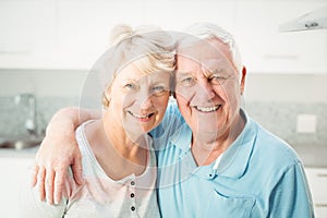 Portrait of cheerful senior couple in kitchen