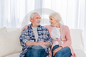 portrait of cheerful senior couple looking at each other while sitting