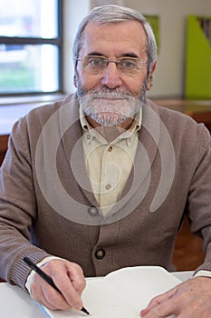 Portrait of cheerful senior man preparing for courses