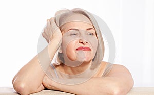 Portrait of cheerful senior woman smiling while looking away at spa. Happy mature woman after spa massage and anti-aging