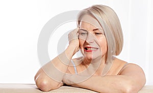 Portrait of cheerful senior woman smiling while looking away at spa. Happy mature woman after spa massage and anti-aging
