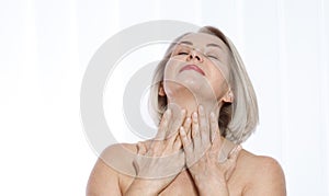 Portrait of cheerful senior woman smiling while looking away at spa. Happy mature woman after spa massage and anti-aging treatment