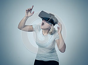 Portrait of cheerful and shocked young woman wearing Virtual Reality headset exploring 3D world