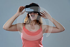 Portrait of cheerful and shocked young woman wearing Virtual Reality headset exploring 3D world