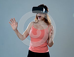 Portrait of cheerful and shocked young woman wearing Virtual Reality headset exploring 3D world