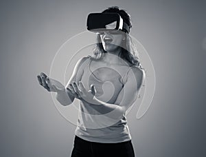 Portrait of cheerful and shocked young woman wearing Virtual Reality headset exploring 3D world