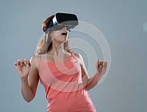 Portrait of cheerful and shocked young woman wearing Virtual Reality headset exploring 3D world