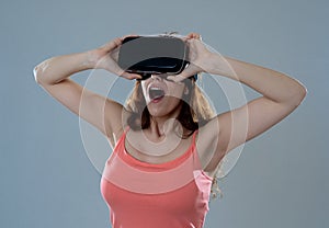 Portrait of cheerful and shocked young woman wearing Virtual Reality headset exploring 3D world