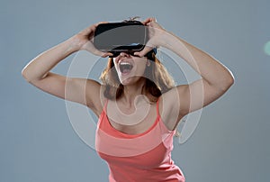 Portrait of cheerful and shocked young woman wearing Virtual Reality headset exploring 3D world