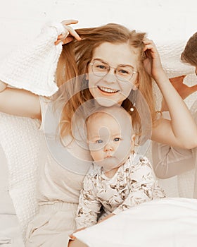 Portrait of cheerful smiling happy woman mother and baby covered white towel baby. Protection safety. Skin care, hygiene