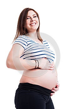 Portrait of cheerful smiling pregnant woman touching her belly