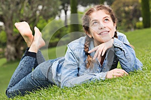 portrait of smiling young girl while lying in outdoors