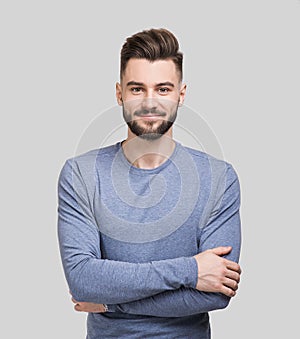 Portrait of cheerful smiling young man with folded arms.