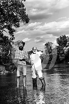 Portrait of cheerful two bearded men fishing. Hobby for soul. Retirement fishery. Friends fishing. Successful fly