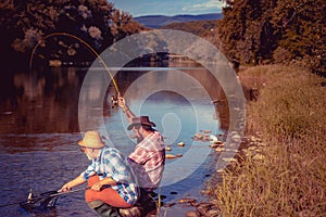Portrait of cheerful two men fishing. Fly fishing. Perfect weekend. Gone fishing. Weekend time. Fisherman with rod